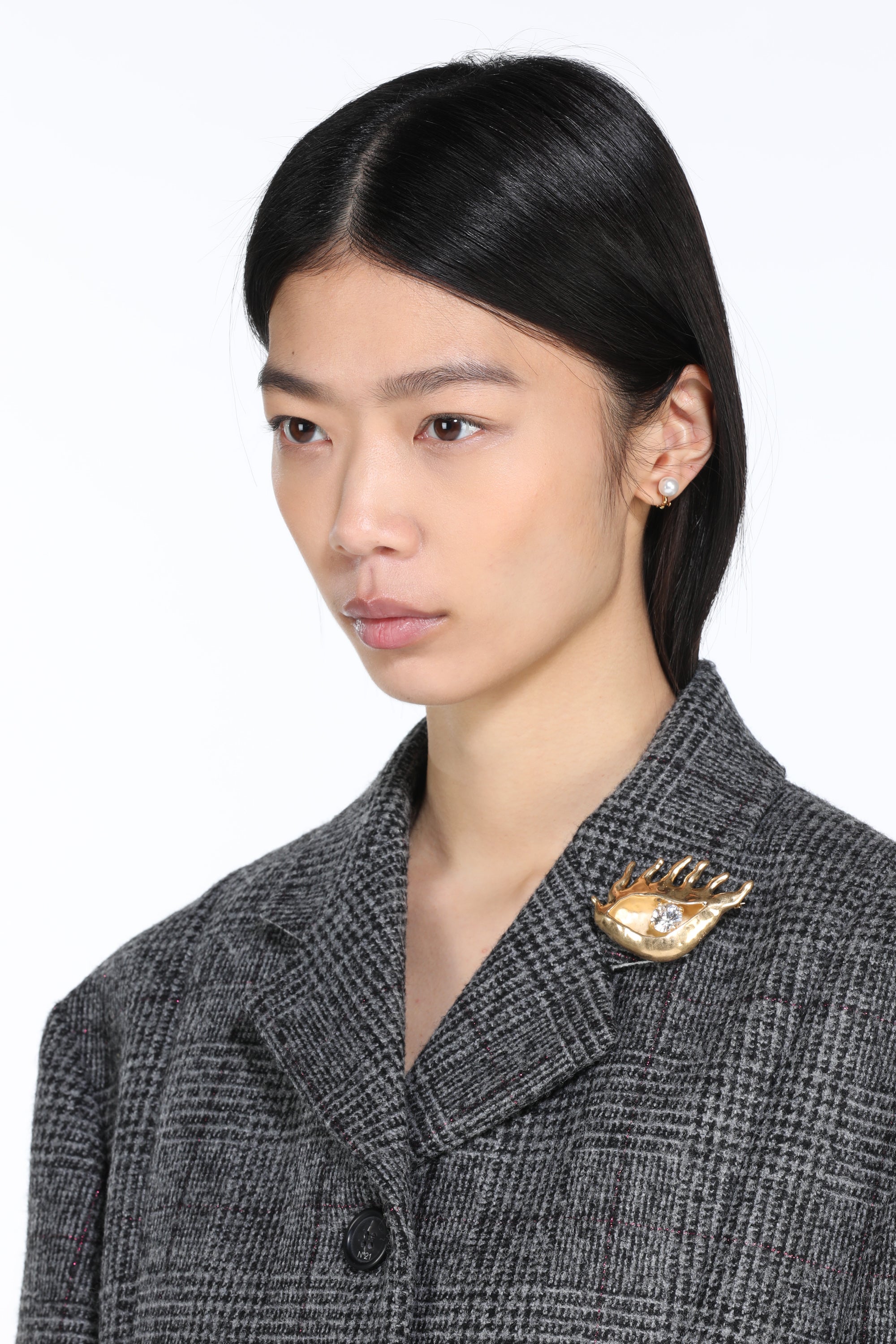 Golden eye-shaped brooch